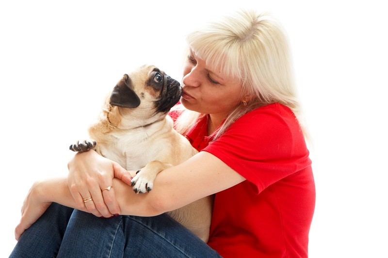 woman kissing pug